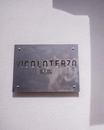 a metal sign on a wall with the words at Vicoloterzo Suite in Bari