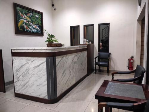 a bar in a lobby with chairs and a table at Hotel Cepu Indah 1 in Cepu