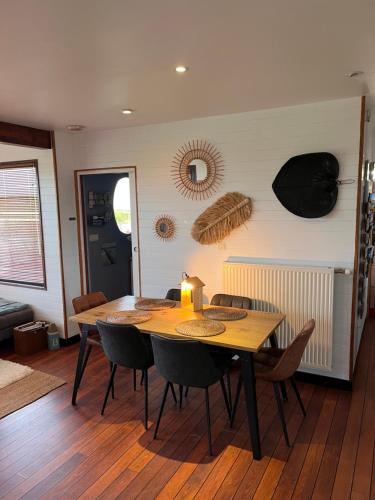 une salle à manger avec une table et des chaises en bois dans l'établissement La Maison Bateau au Bord de Mer, à Guissény
