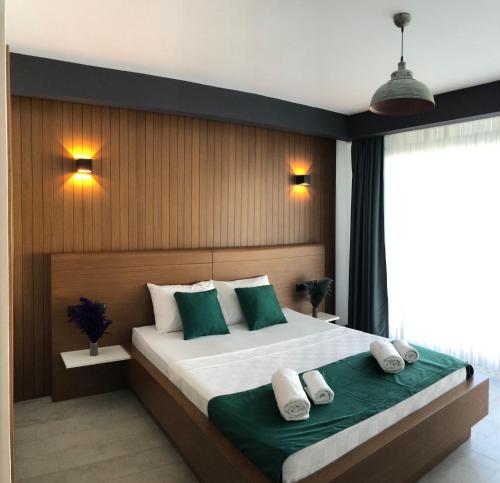 - une chambre dotée d'un grand lit avec des oreillers verts et blancs dans l'établissement SEREN OTEL ÇEŞME, à Çeşme