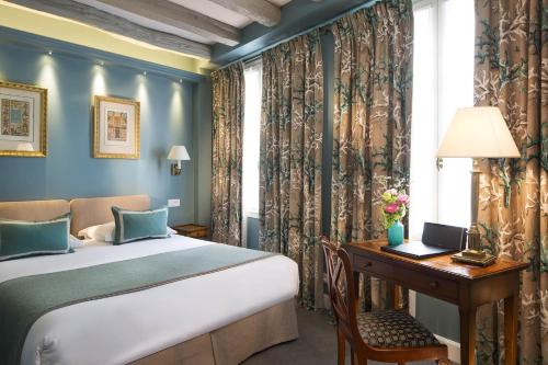 une chambre avec un lit et un bureau avec un ordinateur dans l'établissement Le Relais Saint Honoré, à Paris