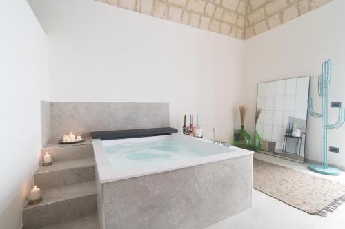 a bathroom with a large bath tub with stairs at Vicoloterzo Suite in Bari