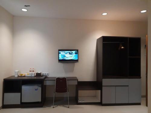 a room with a desk and a tv on a wall at Hotel Cepu Indah 2 in Cepu