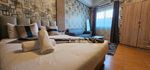 a bedroom with a large bed and a chair at XCESS RESIDENCE in Pattaya South