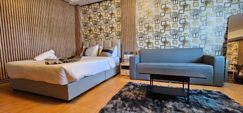 um quarto com uma cama e um sofá azul em XCESS RESIDENCE em Pattaya Sul