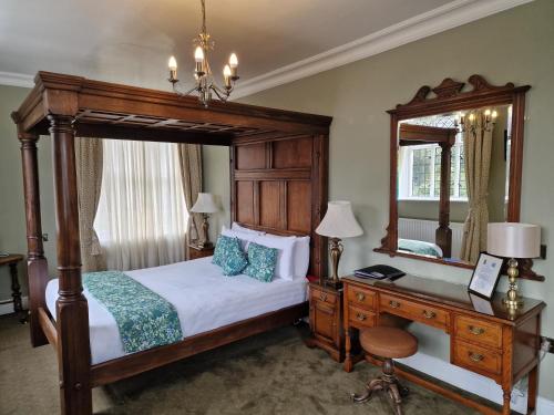 a bedroom with a bed and a desk and a mirror at The Radnorshire Arms Hotel in Presteigne