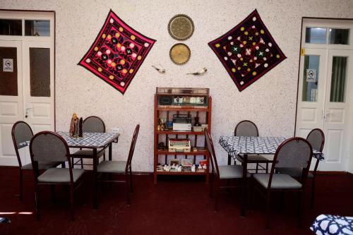 a dining room with two tables and chairs and flags at World Guest House in Samarkand
