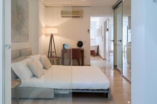 um quarto com uma cama branca e uma sala de estar em Mari Lifestyle em Fano
