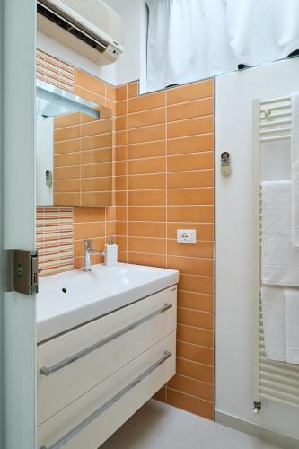 a bathroom with a white sink and orange tiles at Mari Lifestyle in Fano