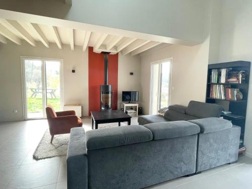 een woonkamer met een bank en een tafel bij Maison entre lacs et fôrets in Montréal La Cluse