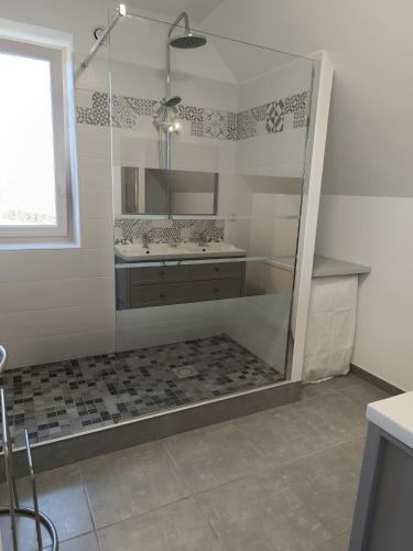 a bathroom with a shower with two sinks and a mirror at Grande Maison de plain pied avec jardin arboré. in Champignelles