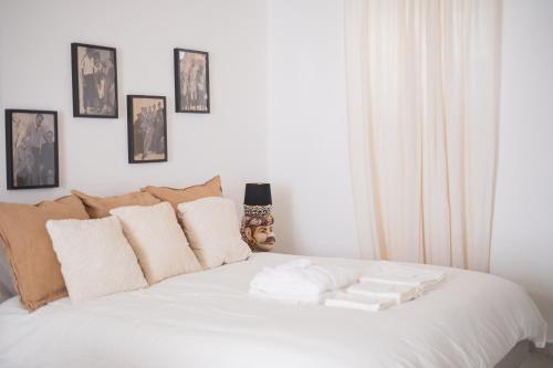 a bedroom with a white bed with white pillows at Vicoloterzo Suite in Bari
