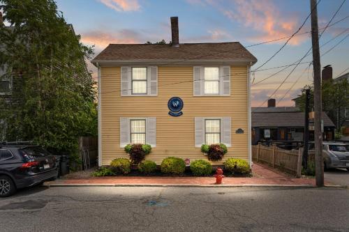 a yellow house with a fire hydrant in front of it at Downtown Steps to Waterfront "The Garden" in Newburyport