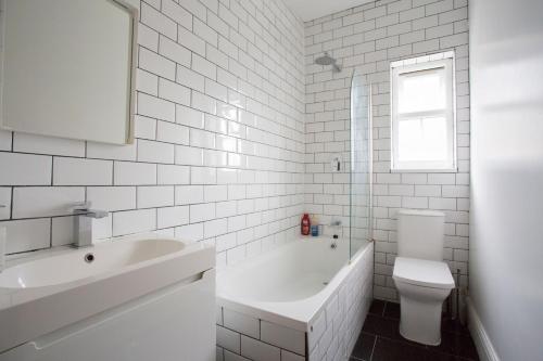 Baño blanco con lavabo y aseo en Double Room Haggerston en Londres