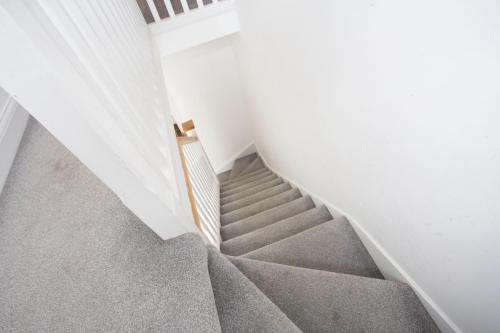 una escalera en una casa con alfombra gris en Double Room Haggerston en Londres