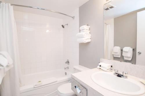 a white bathroom with a sink and a toilet at Sandman Inn Cache Creek in Cache Creek