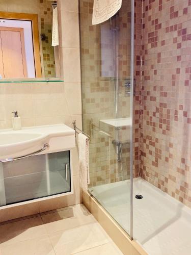 a bathroom with a glass shower and a sink at Apartamento con vistas Peralada in Peralada