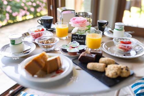 a table topped with plates of food and orange juice at Villa Cri Cri B&B di Charme in San Benedetto del Tronto