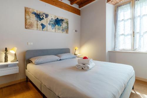 a bedroom with a large white bed with towels on it at “Antica terrazza” Charme&relax in Bergamo