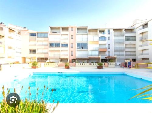 une grande piscine devant un immeuble dans l'établissement Résidence Richelieu port position centrale studio cosy 2 adultes piscine place de parking privative vue Mont Saint Martin, au Cap d'Agde