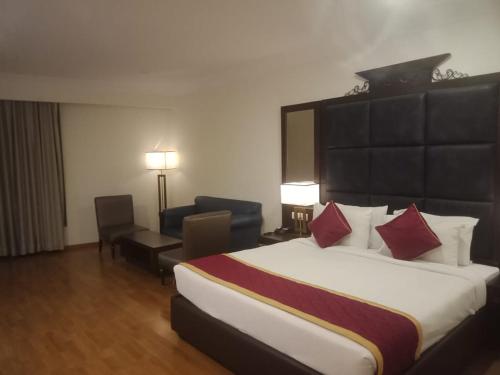 a hotel room with a large bed with red pillows at Hotel Svm Pride Banjara-Hot Live Counter-Road View Stay- Free Lavish Buffet Breakfast-18 Percent Off In Restaurant Food Order in Hyderabad