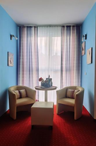 a living room with two chairs and a table and a window at Holding in Tulln