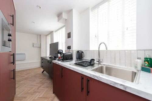 uma cozinha com um lavatório e uma bancada em Cityscape Charm Studio - Central London em Londres