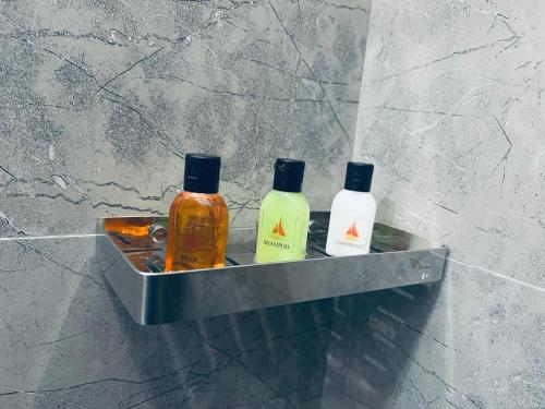 three bottles of soap in a metal shelf in a bathroom at Mama’s Boutique Beach Hotel in Negombo