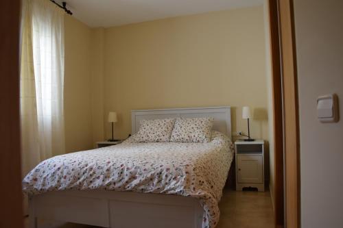a bedroom with a bed and two lamps and a window at La abuela Isabel Piso con encanto Arnedillo in Arnedillo