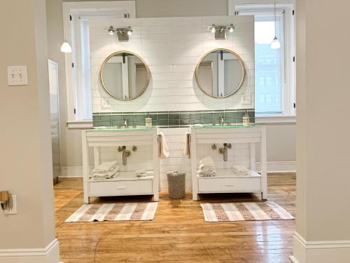 a bathroom with two sinks and two mirrors at The Historic Lyric Presidential Suite in Cincinnati