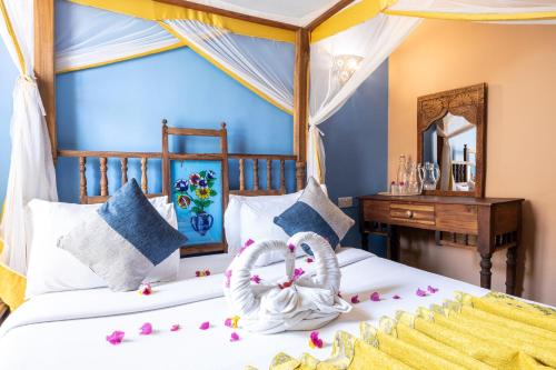 a bedroom with two beds with flowers on the bed at Shaba Boutique Hotel in Zanzibar City