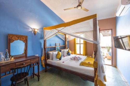 a bedroom with a bed with a dresser and a mirror at Shaba Boutique Hotel in Zanzibar City