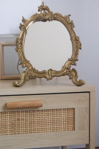 un espejo ornamentado sentado en la parte superior de un tocador en Estrela de mar en O Grove