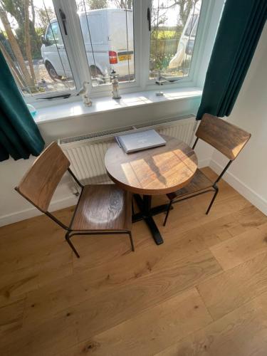a table and two chairs in a room with a window at Godden Green B & B Guesthouse in Newchurch