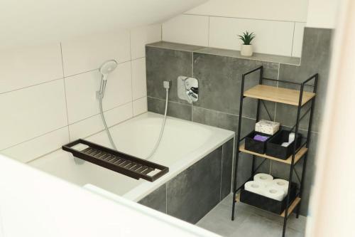 ein Bad mit einer Badewanne, einer Dusche und einem Waschbecken in der Unterkunft WIESENglück in Altusried