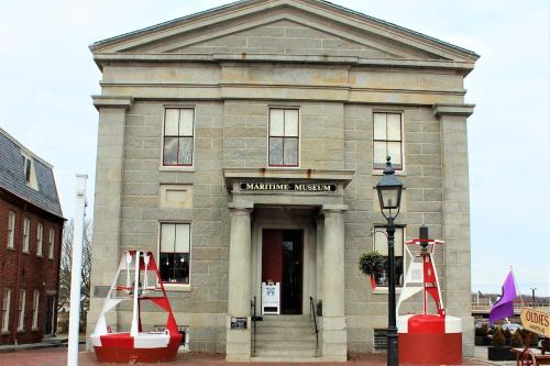 a building with red barriers in front of it at Steps to Downtown Rooftop Deck Flexible Temp Stay in Newburyport