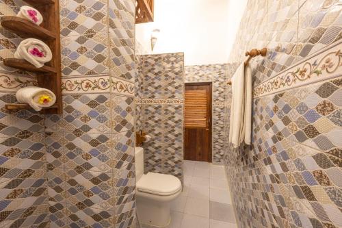 a bathroom with a toilet and a tiled shower at Shaba Boutique Hotel in Zanzibar City
