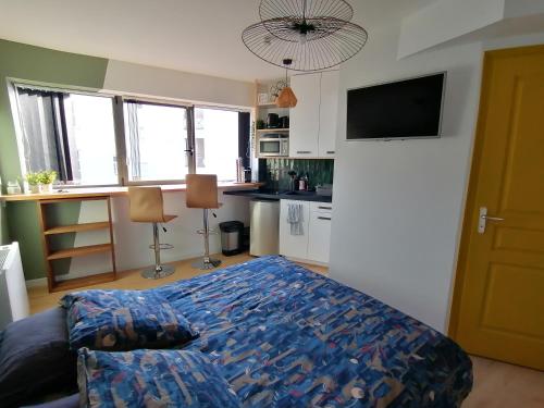 Cet appartement comprend une chambre avec un lit et une cuisine avec des fenêtres. dans l'établissement Vannes: charmant studio sur le port, à Vannes
