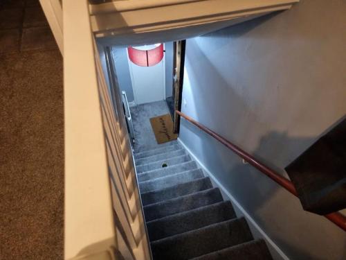 Blick auf eine Treppe in einem Gebäude mit einem roten Fenster in der Unterkunft Comfy 1st floor flat, sleeps 4 in London