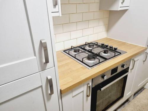 a kitchen with a stove top oven in a kitchen at Comfy 1st floor flat, sleeps 4 in London