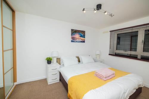 a white bedroom with a bed and a window at Dannyrex Apartments in Northampton