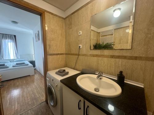 a bathroom with a sink and a washing machine at K3 in Budapest
