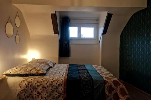 a bedroom with a bed with a window at L'Art Déco - Maison + Parking (Portes de Chartres) in Jouy