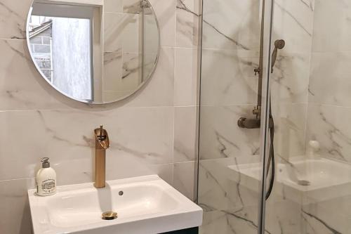 a white bathroom with a sink and a mirror at L'Art Déco - Maison + Parking (Portes de Chartres) in Jouy