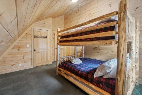 1 Schlafzimmer mit 2 Etagenbetten in einem Blockhaus in der Unterkunft The Log Castle Hot Tub 10 Minutes to Skiing in Killington