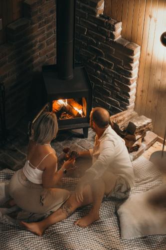 a man and woman sitting in front of a fireplace at The Polish Place in Mount Tamborine
