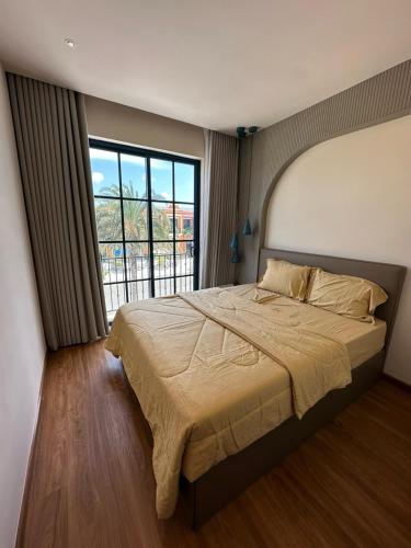 a bedroom with a large bed and a large window at Holiday Villa Novaworld Phan Thiet in Phan Thiet