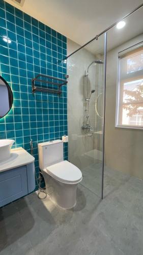 a bathroom with a toilet and a glass shower at Holiday Villa Novaworld Phan Thiet in Phan Thiet