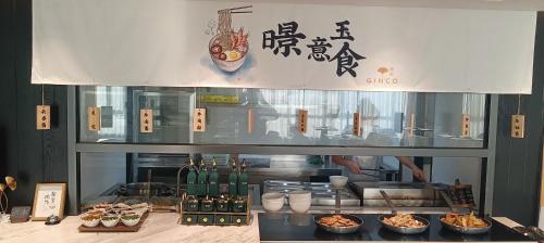 GINCO Hotel Guangzhou Baiyun Airport في قوانغتشو: مطعم مع بعض الطعام على كاونتر