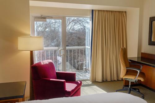 WestlakeにあるMarriott Dallas/Fort Worth Westlakeのベッド1台、椅子、窓が備わる客室です。